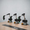 Three robotic arms together clamp building blocks